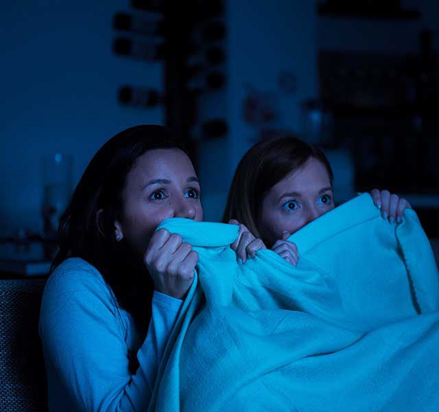 two women watching a scary movie