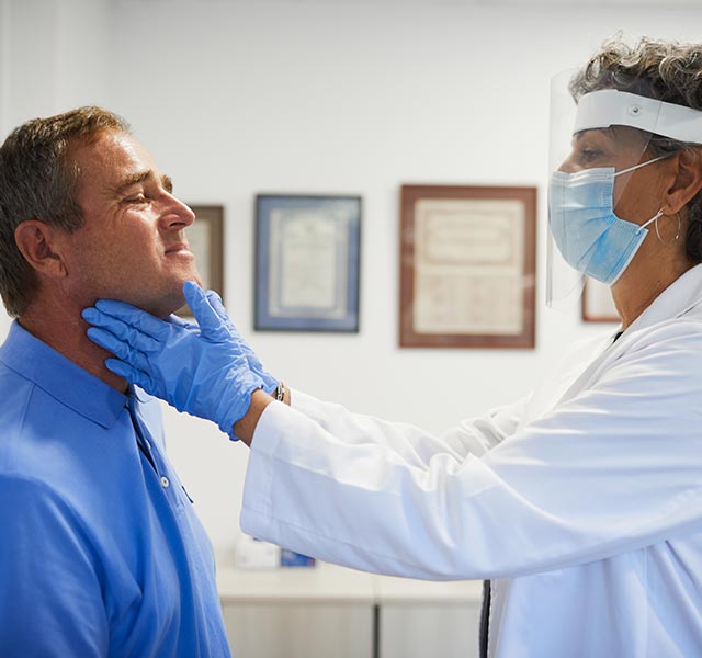 doctor checking patient thyroid