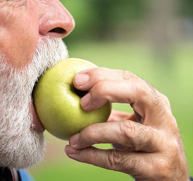 old man eating apple