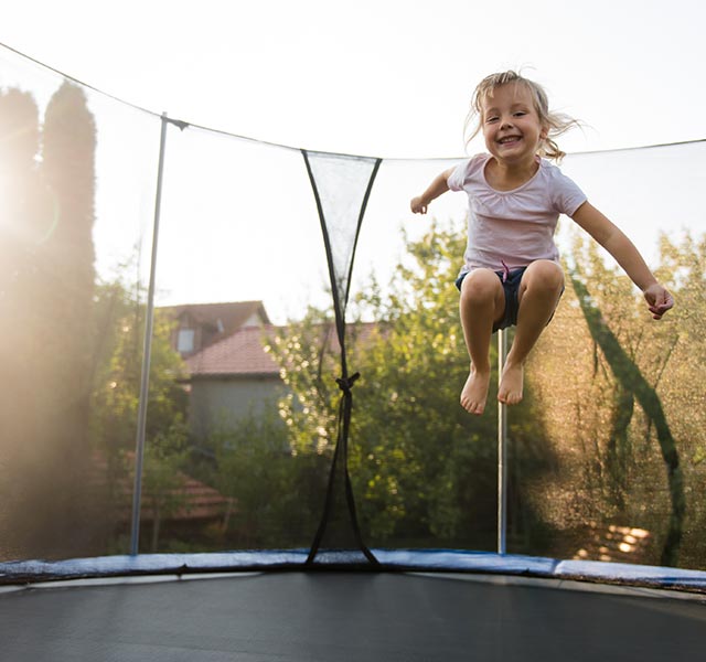 little girl jumping on trampoline