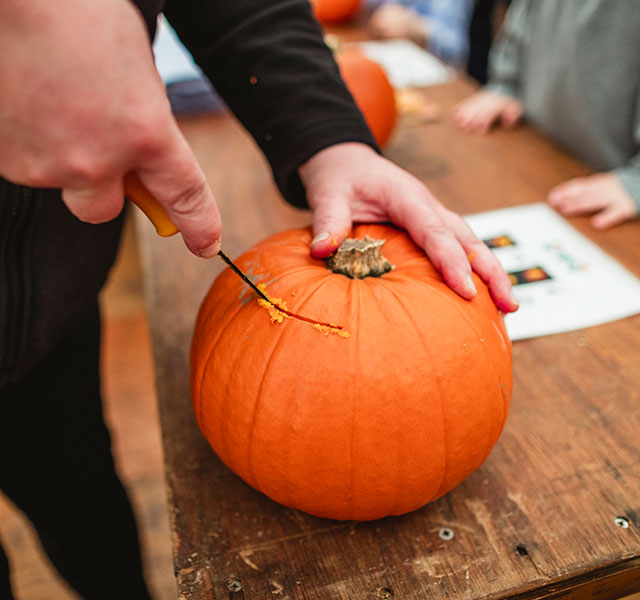 man carving pumpkin