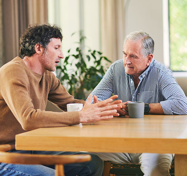two men talking at table