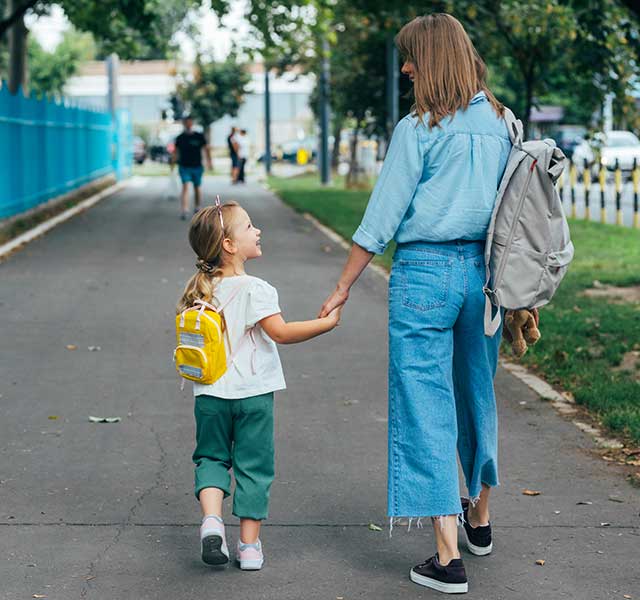 Mom walking daughter to school