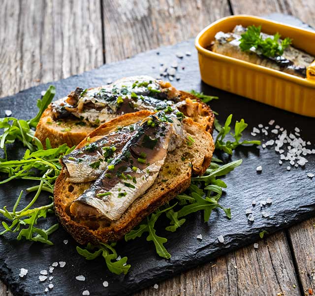 Canned sardines on toast with fresh herbs and arugula sardines superfood