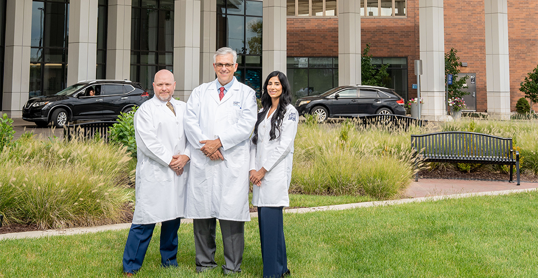 Three vascular doctors standing outside a hospital