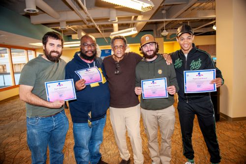 WIN Network fathers and support persons stand together holding their ‘Super Dad Award’ certificates, recognizing their exceptional support and dedication to ensuring a healthy and joyful journey for both mother and baby.