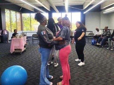 WIN Network community health workers lead a group activity with participants in a shared indoor space, encouraging engagement, movement, and connection.