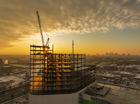 The sunrising in the background of the construction frame work of Destination Grand