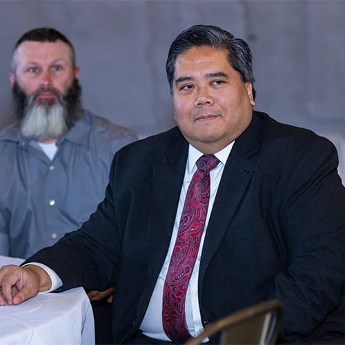 Dr. Santos sitting at a table at a dinner event.