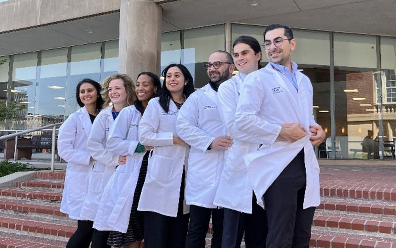 Group photo of fellows in white coats