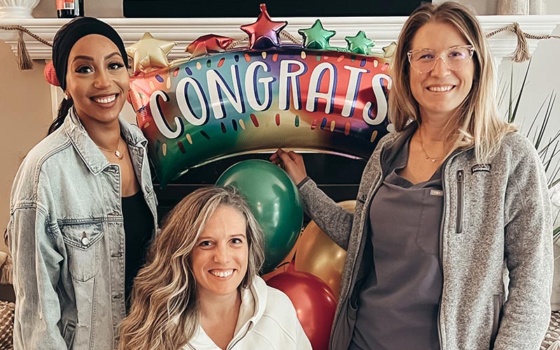 Group of fellows celebrating together in front of a Congrats banner