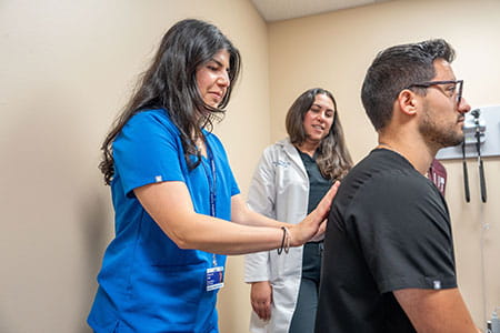 Resident physician performs a physical examination under faculty supervision at Henry Ford Health Seville Family Medicine clinic.