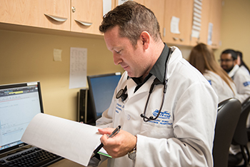 resident reviewing patient chart