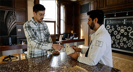 Dr. Avi Cohen demonstrates the AIRS respiratory monitoring device to Alexander Reynolds. 