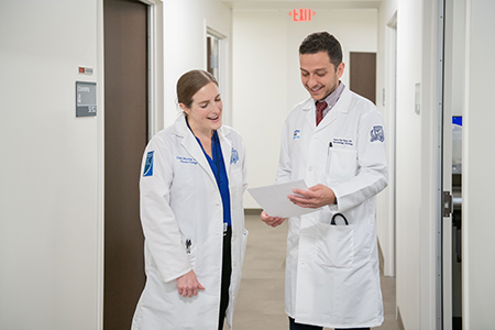Oncologists at Henry Ford Health in Detroit stand together to review information about cancer treatment plans.
