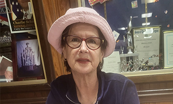 Pancreatic cancer patient, Ondina, sitting in front of awards