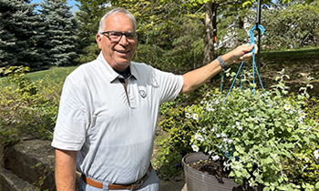 Prostate cancer patient, Jon, holding hanging flower basket