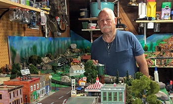 ENT patient Albert posed behind his train set