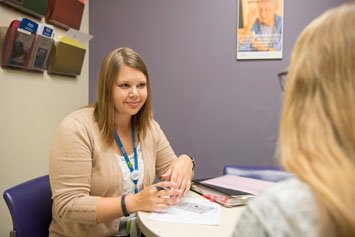 A genetics counselor goes over genetic testing results with a patient in a clinic setting.