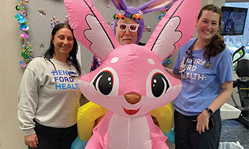 Patient Bob with two of his rehabilitation caregivers posing with an inflatable bunny during the Easter season.