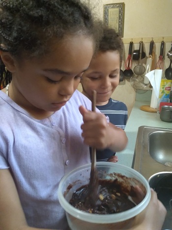 Young girl stirring a bowl of chocolate in the kitchen