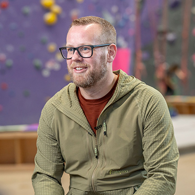 vascular surgery patient Eric sitting on bench at the climbing gym