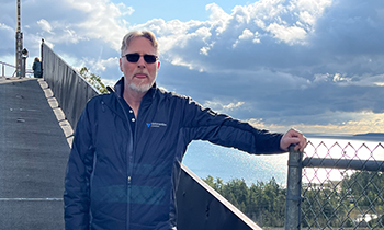 Mike posed on a bridge outdoors