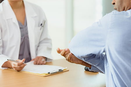 Doctor listening to a patient talking about elbow pain
