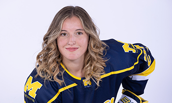 Grace smiling and posed for photo in hockey uniform.