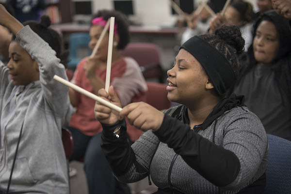girls using drumsticks to make music