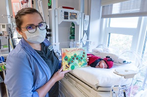 Nurse with book and baby dressed as ladybug